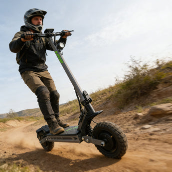 Person riding a large vipcoo vs2 pro off-road electric scooter on a dirt path.