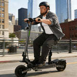 A heavy duty Person riding an vipcoo vs2 pro electric scooter on a city street with tall buildings in the background