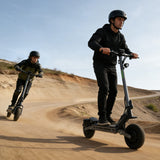 Two people riding vipcoo vs2 pro off road electric scooters on a dirt path with a clear sky.